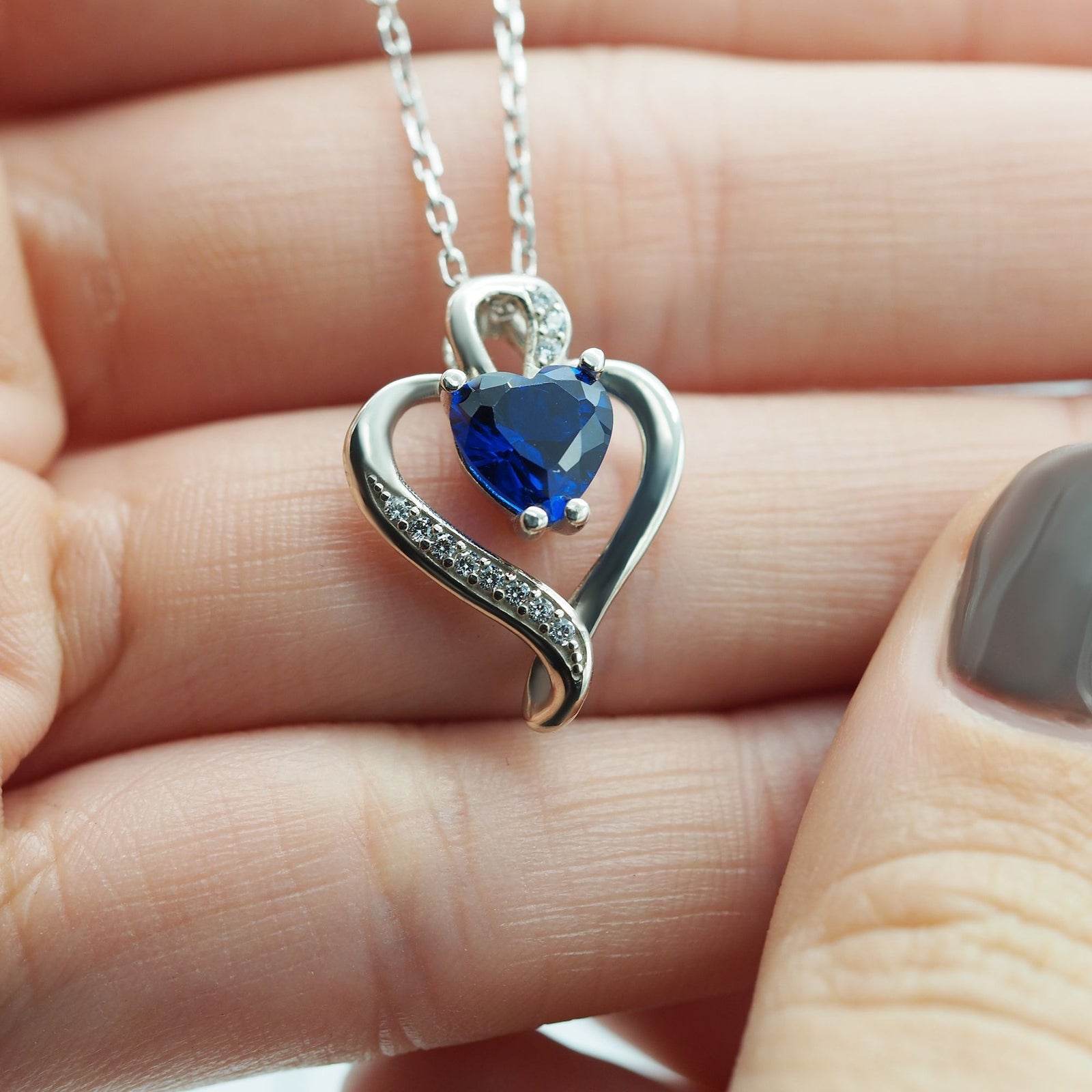 Collar Nina de plata con piedra azul sobre una mano - Andrea Jewels