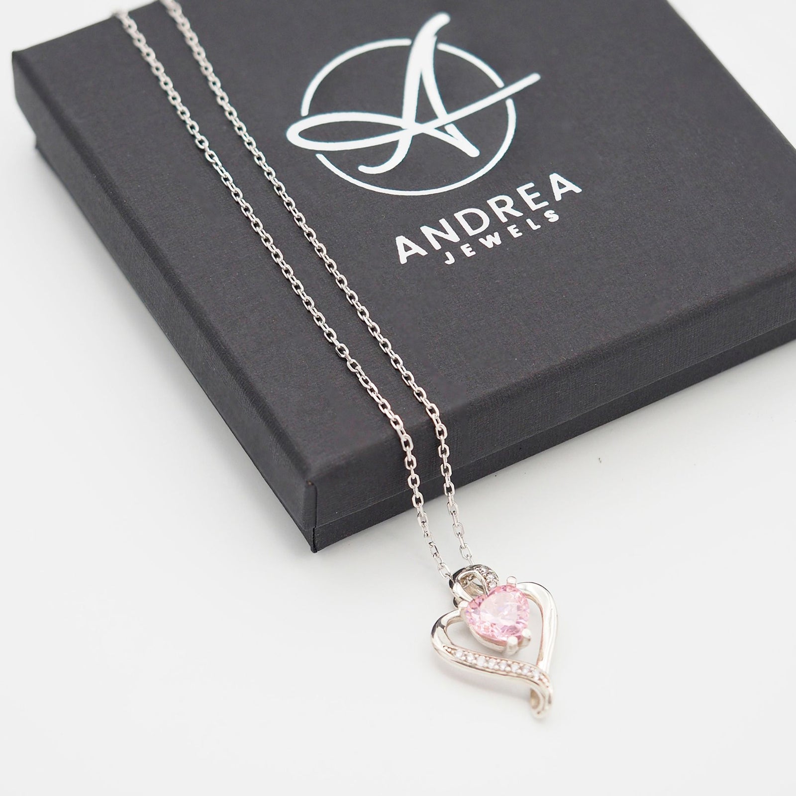 Collar Nina de plata con piedra rosa junto a su caja de regalo cerrada - Andrea Jewels