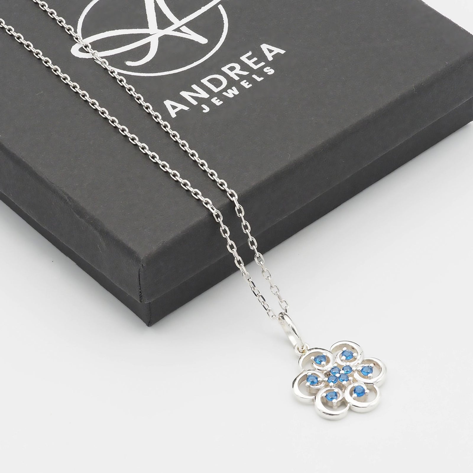 Collar Poppy de plata 925 con piedras azules junto a su caja de regalo cerrada - Andrea Jewels