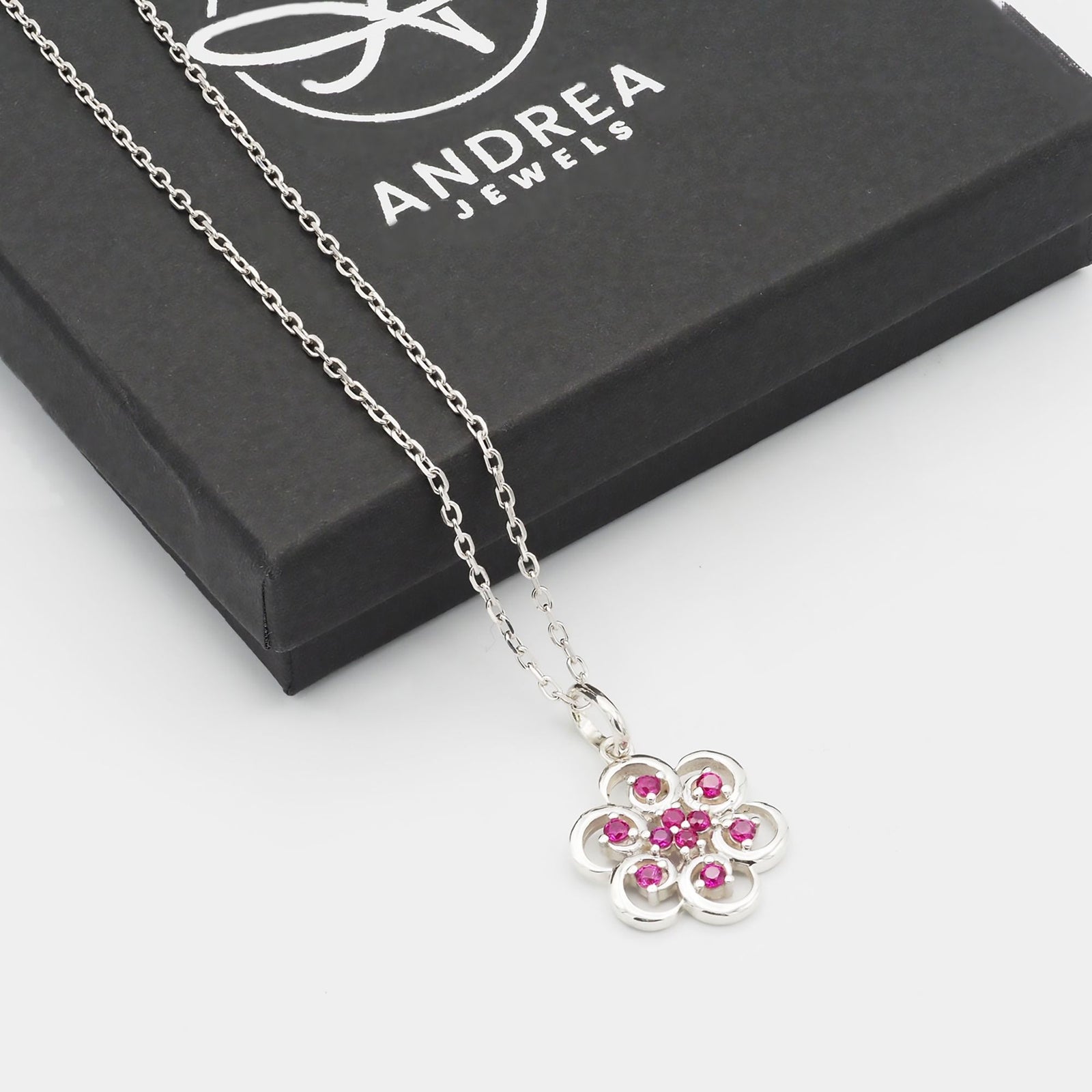 Collar Poppy de plata 925 con piedras rojas junto a su caja de regalo cerrada - Andrea Jewels