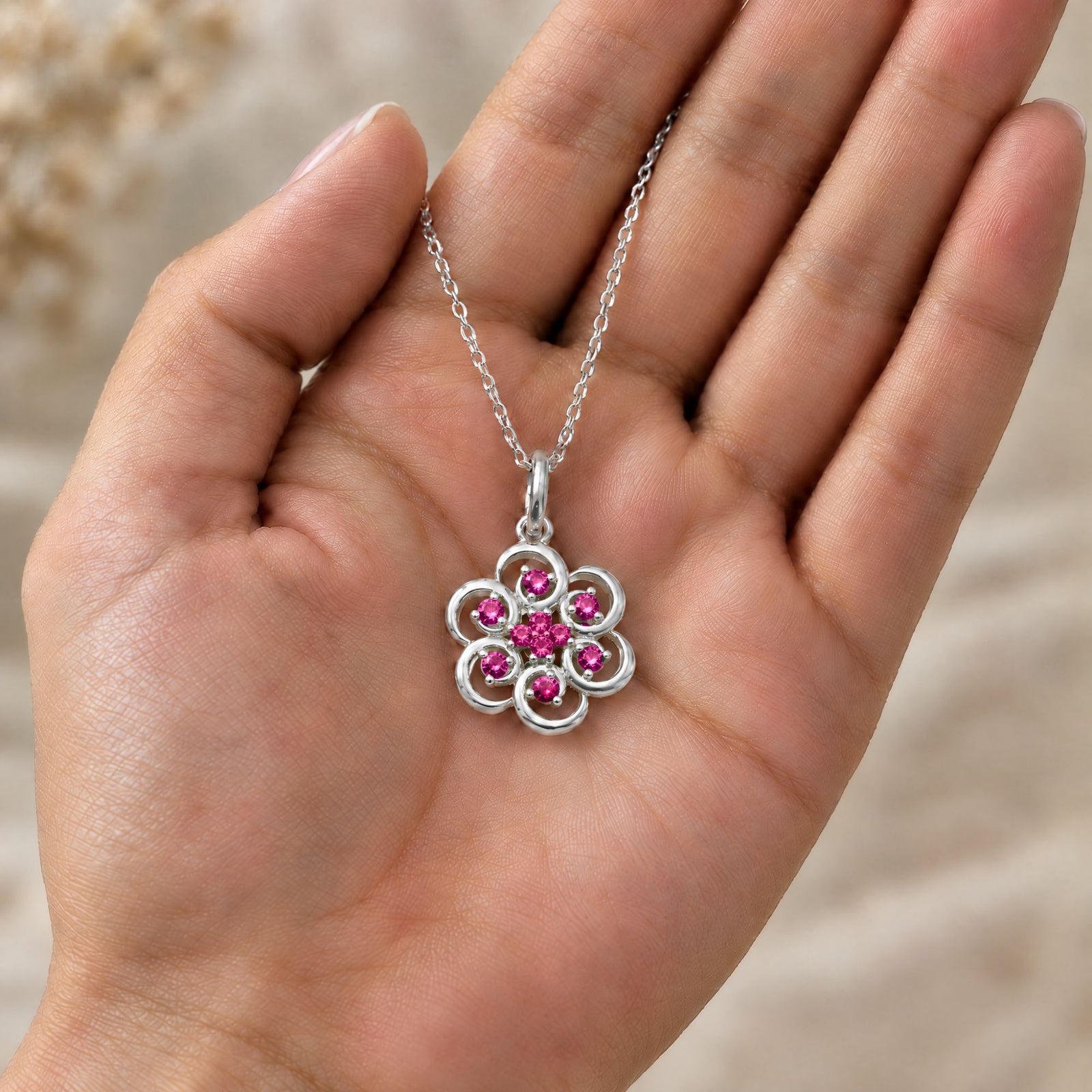 Collar Poppy de plata 925 con piedras rojas sobre una mano - Andrea Jewels