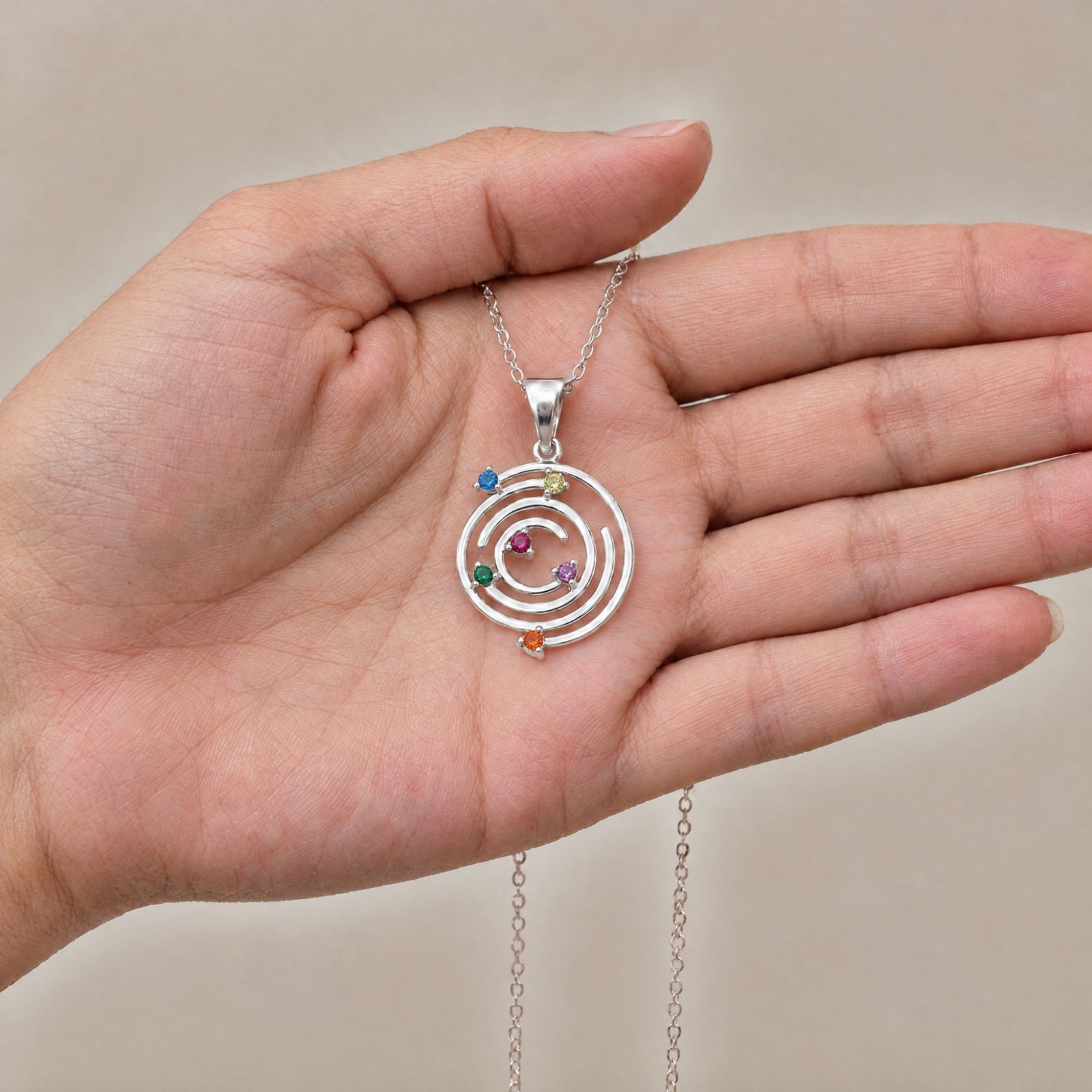 Collar Spiral de plata con piedras multicolor sobre una mano - Andrea Jewels