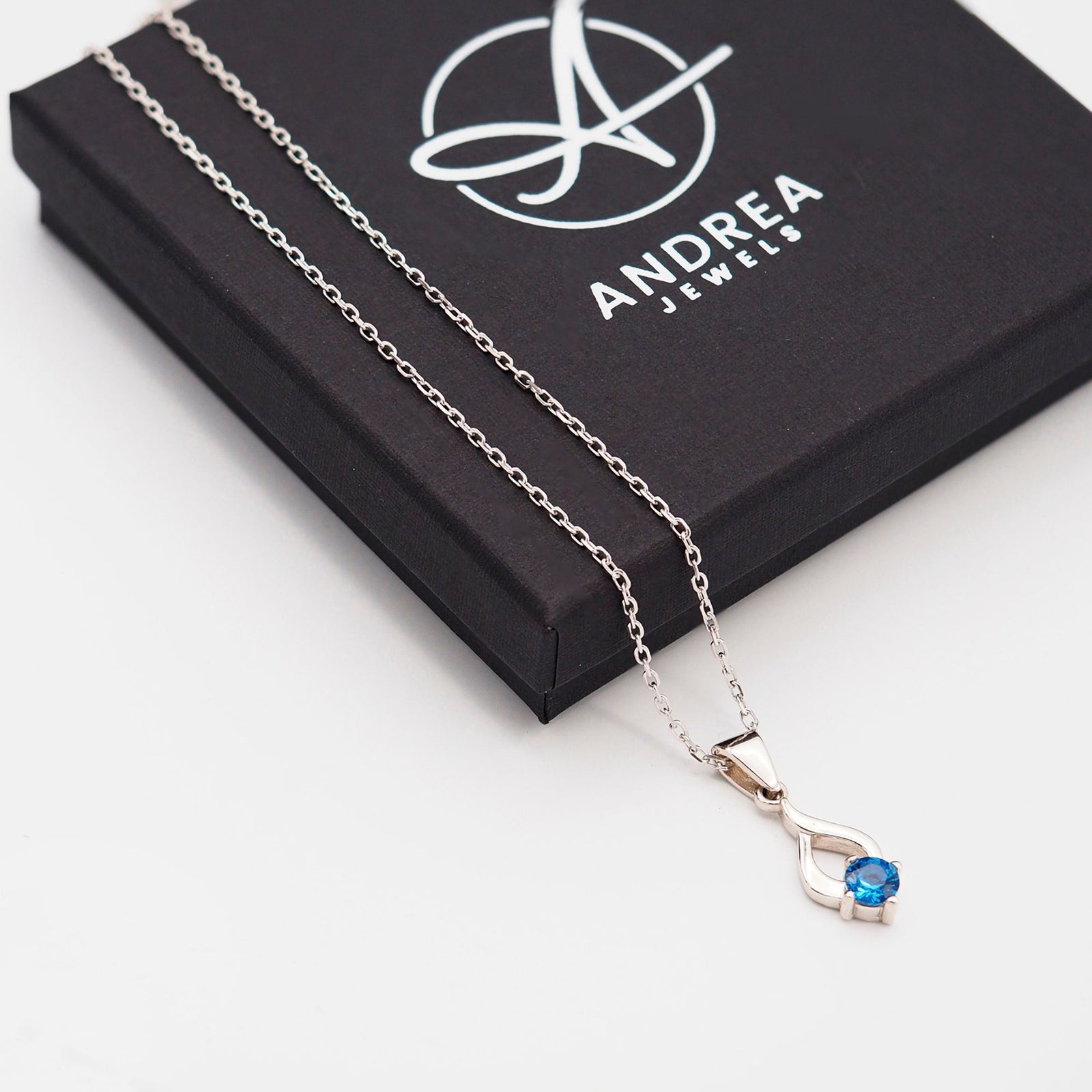 Collar Tear de plata con piedra azul junto a su caja de regalo cerrada - Andrea Jewels