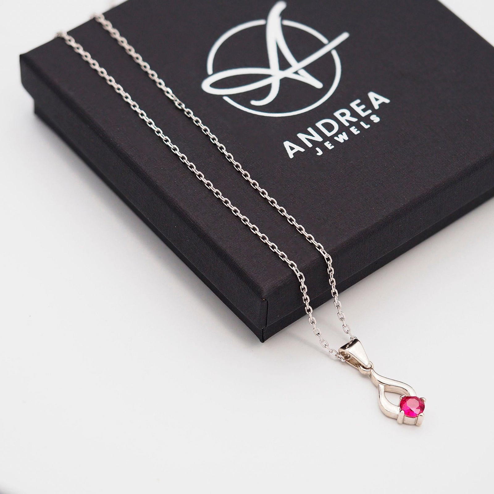 Collar Tear de plata con piedra roja junto a su caja de regalo cerrada - Andrea Jewels