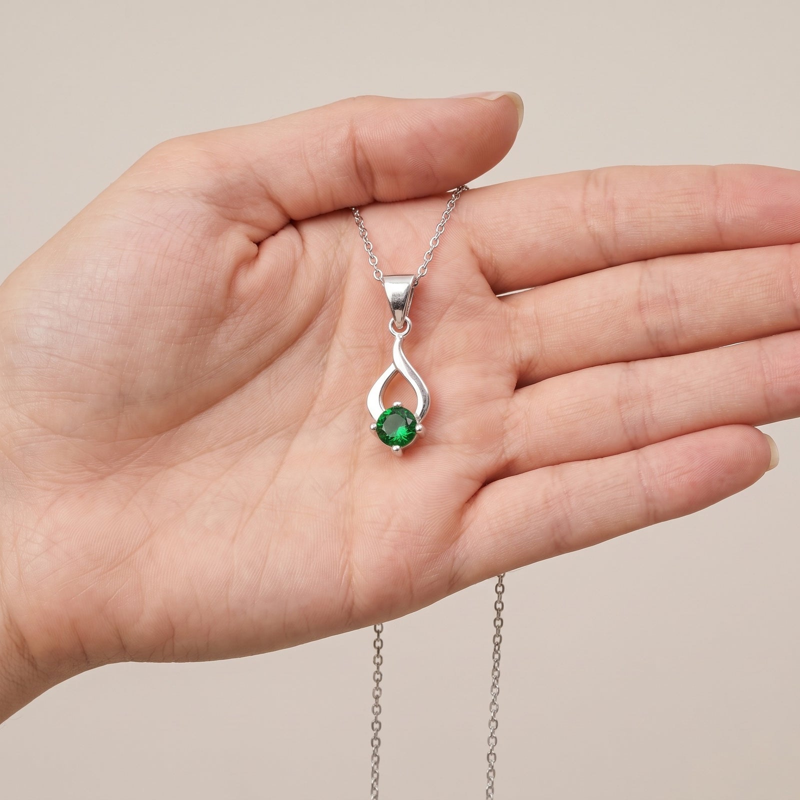 Collar Tear de plata con piedra verde sobre una mano - Andrea Jewels