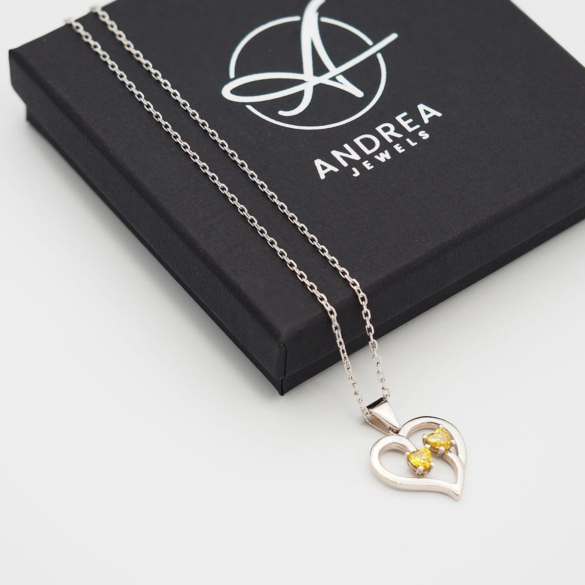 Collar Duo de plata con dos piedras amarillas junto a su caja de regalo cerrada - Andrea Jewels