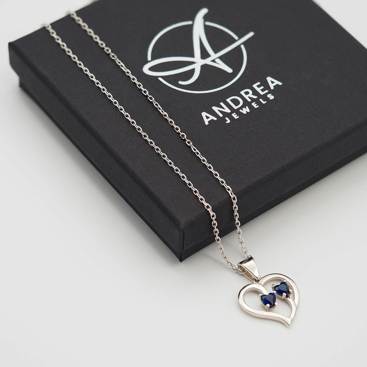 Collar Duo de plata con piedra azul junto a su caja de regalo cerrada - Andrea Jewels
