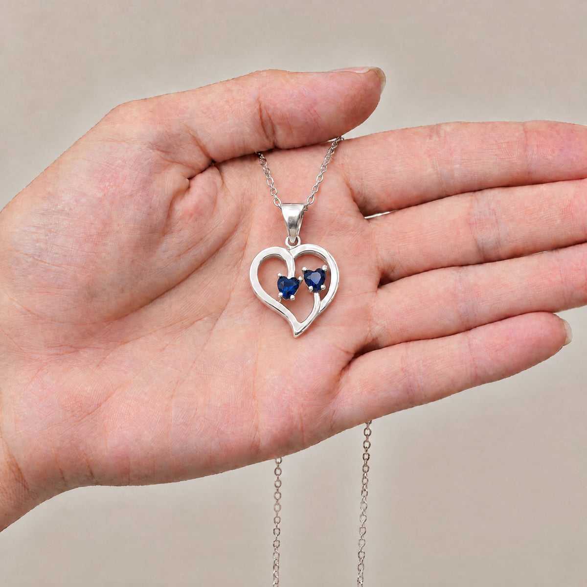 Collar Duo de plata con piedra azul sobre una mano - Andrea Jewels