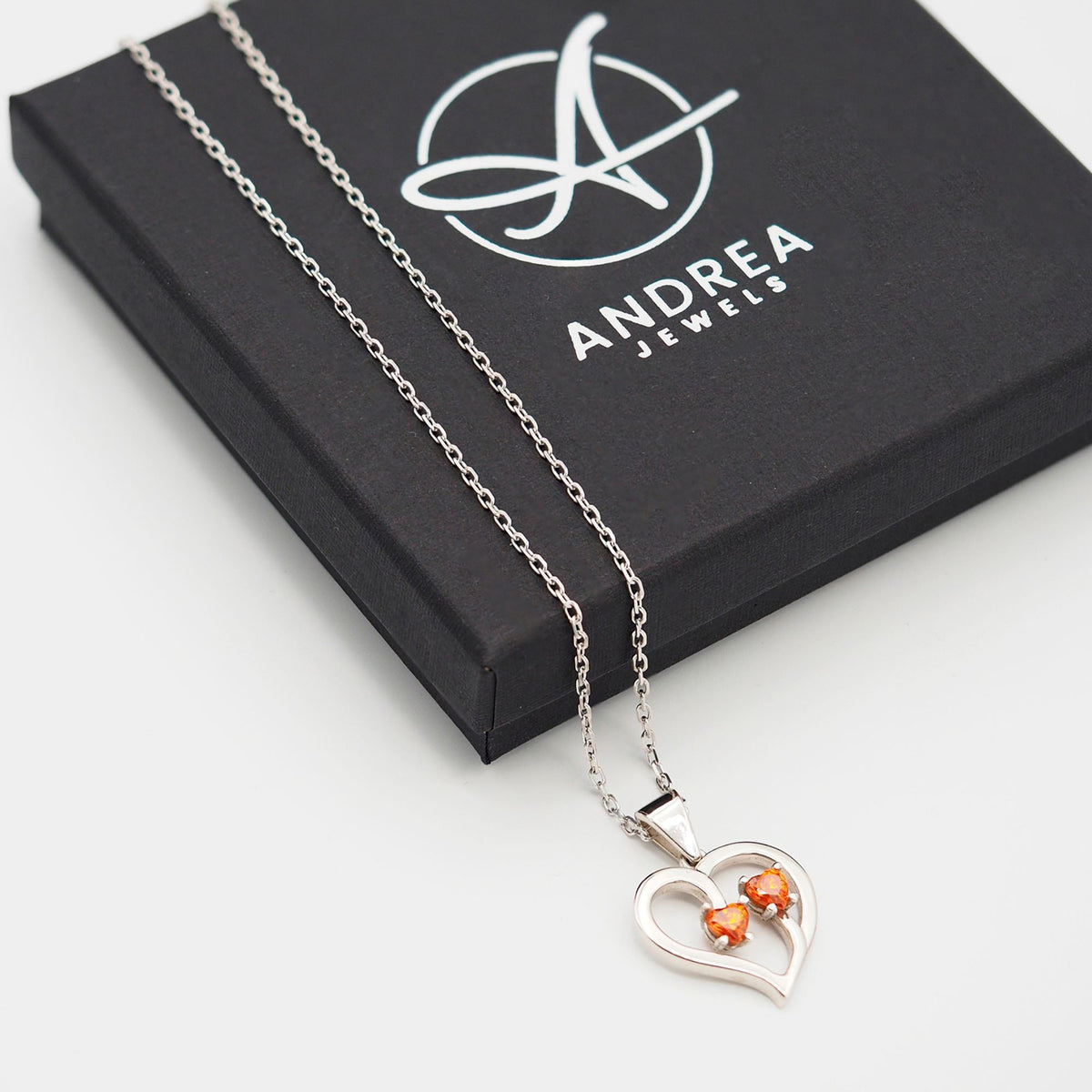 Collar Duo de plata con dos piedras naranjas junto a su caja de regalo cerrada - Andrea Jewels