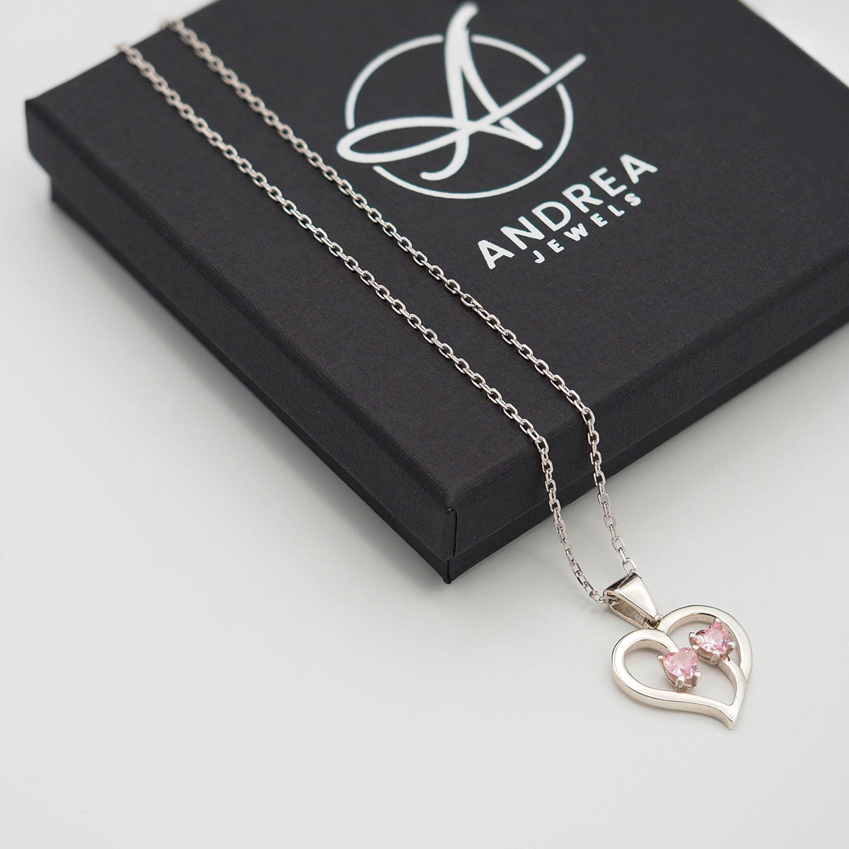 Collar Duo de plata con dos piedras rosas junto a su caja de regalo cerrada - Andrea Jewels