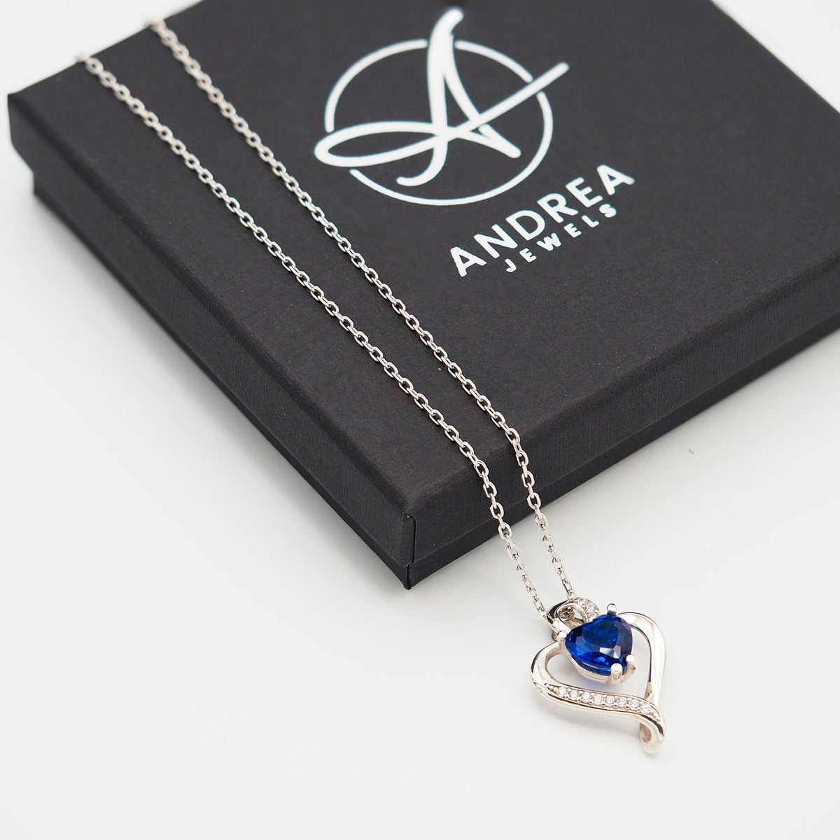 Collar Nina de plata con piedra azul junto a su caja de regalo cerrada - Andrea Jewels