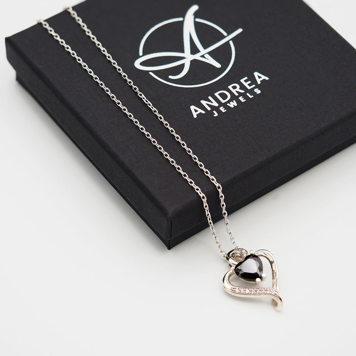 Collar Nina de plata con piedra negra junto a su caja de regalo cerrada - Andrea Jewels