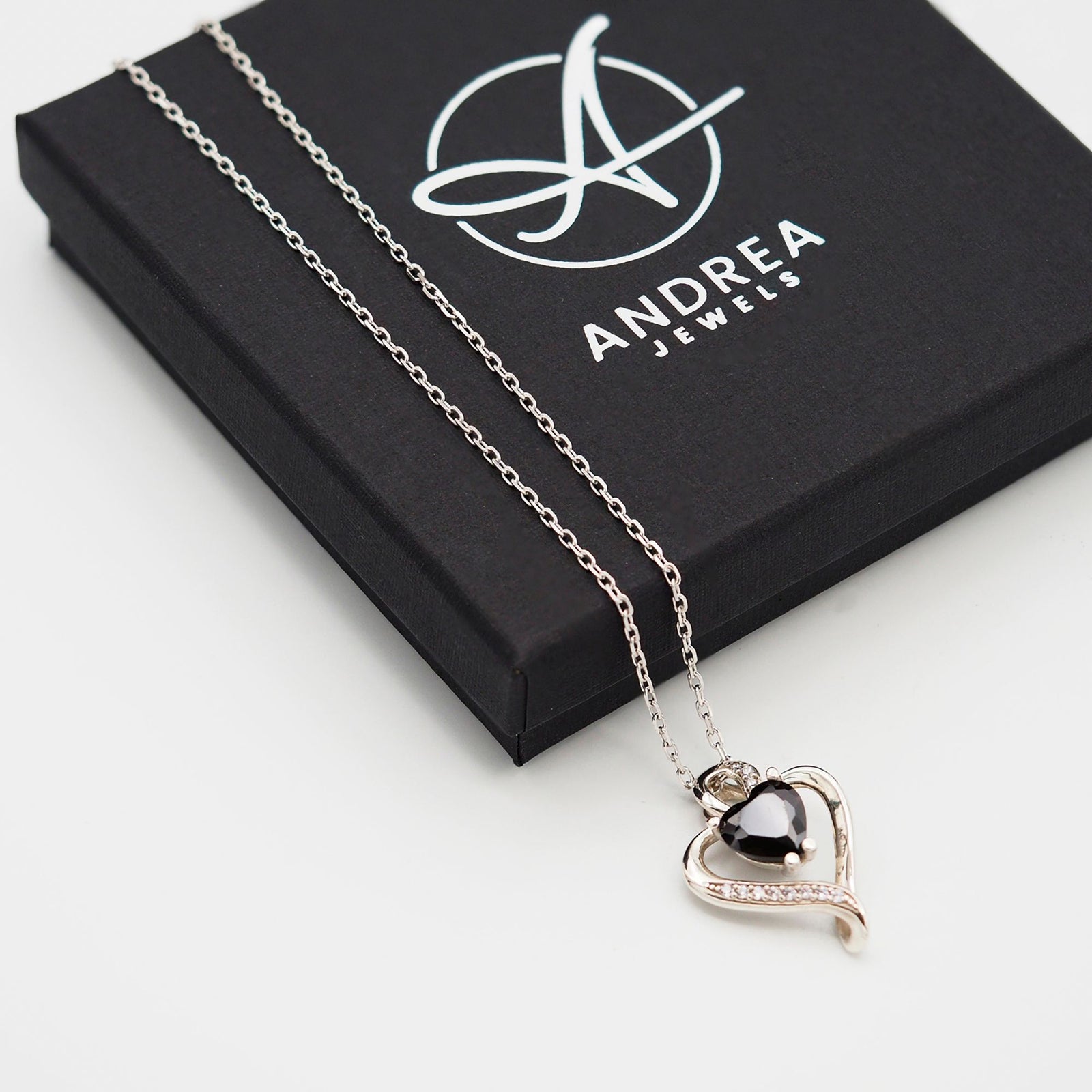 Collar Nina de plata con piedra negra junto a su caja de regalo cerrada - Andrea Jewels