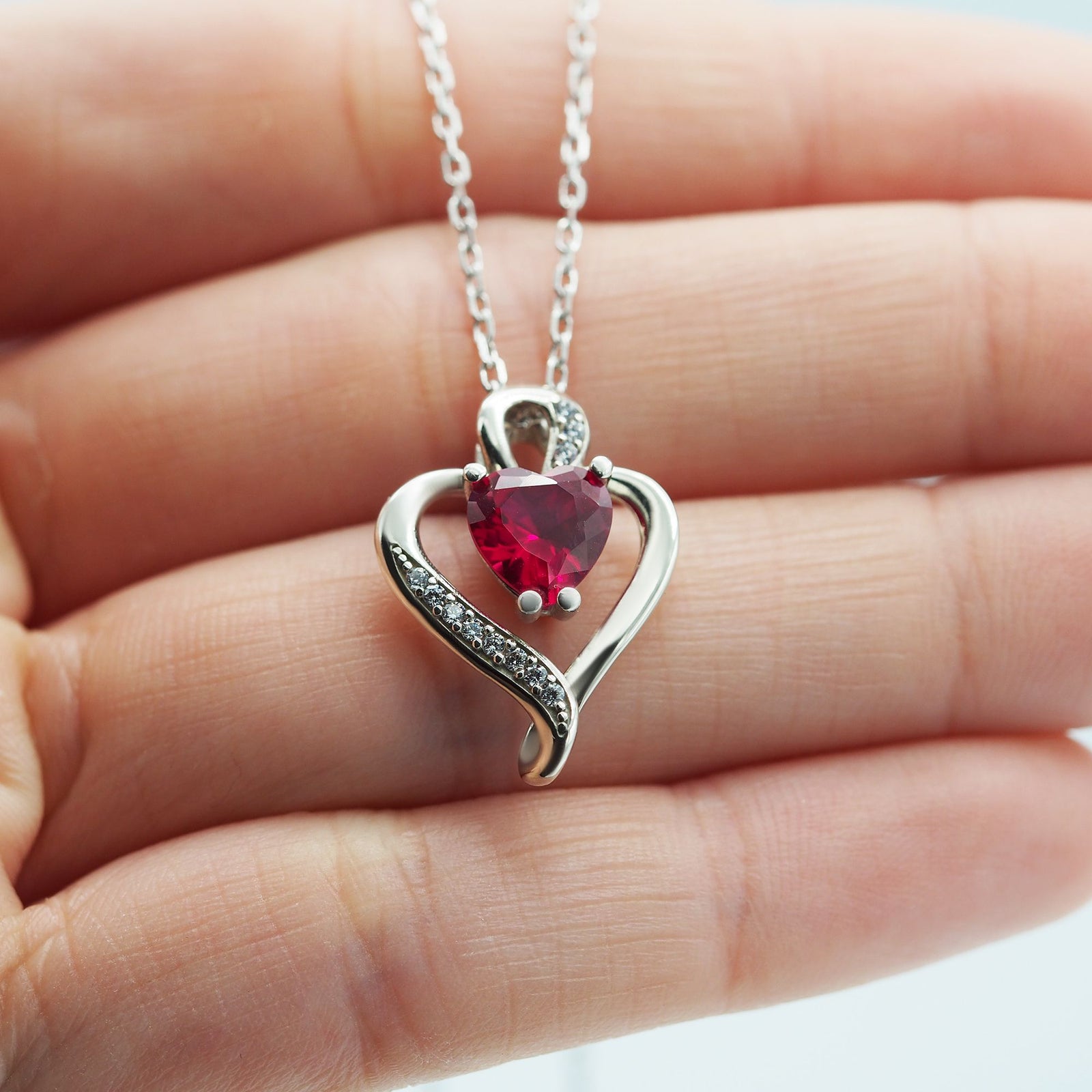 Collar Nina de plata con piedra roja sobre una mano - Andrea Jewels