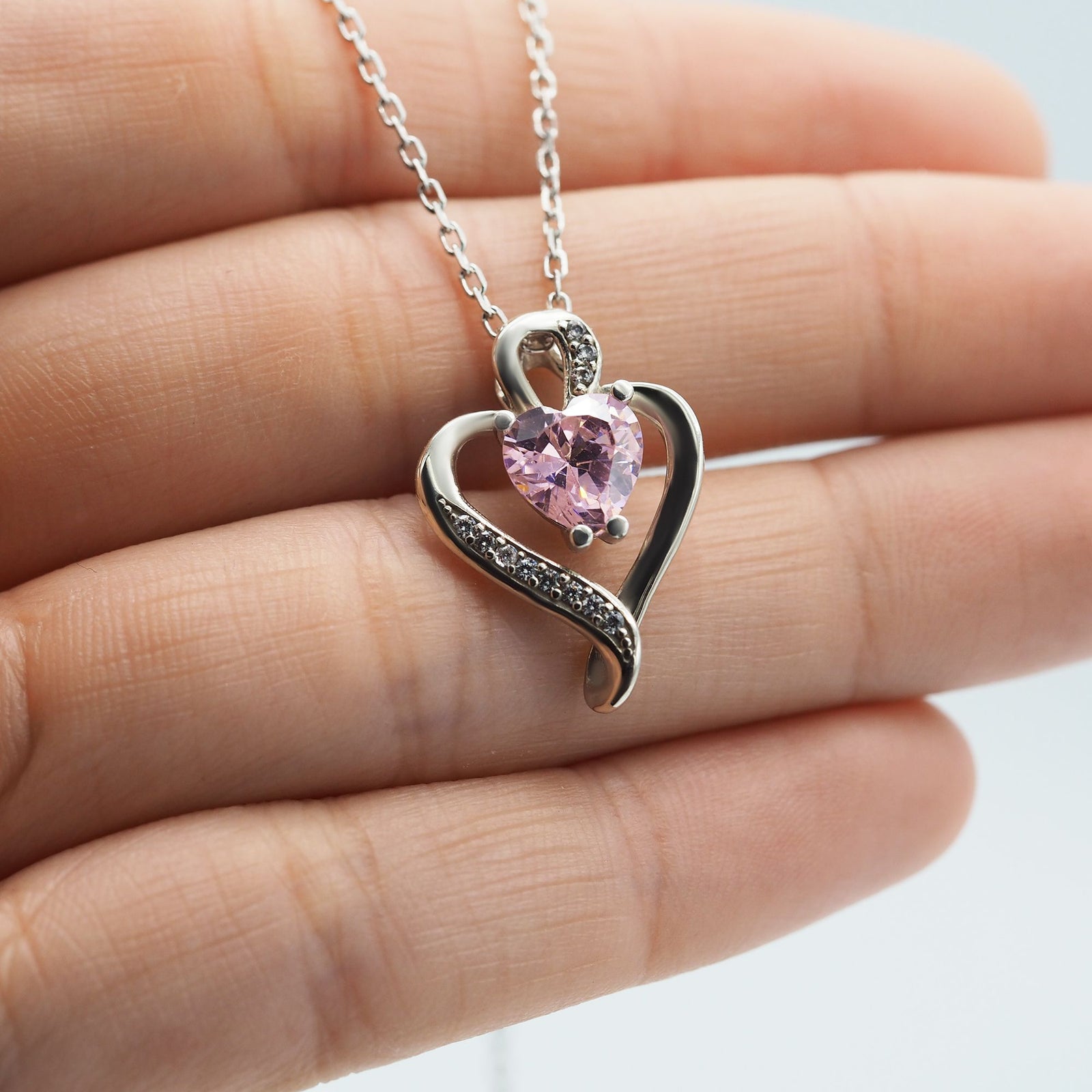 Collar Nina de plata con piedra rosa sobre una mano - Andrea Jewels