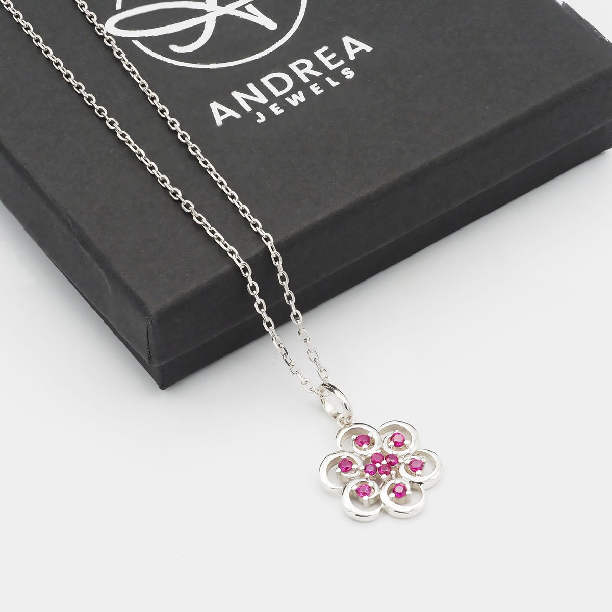 Collar Poppy de plata 925 con piedras rojas junto a su caja de regalo cerrada - Andrea Jewels