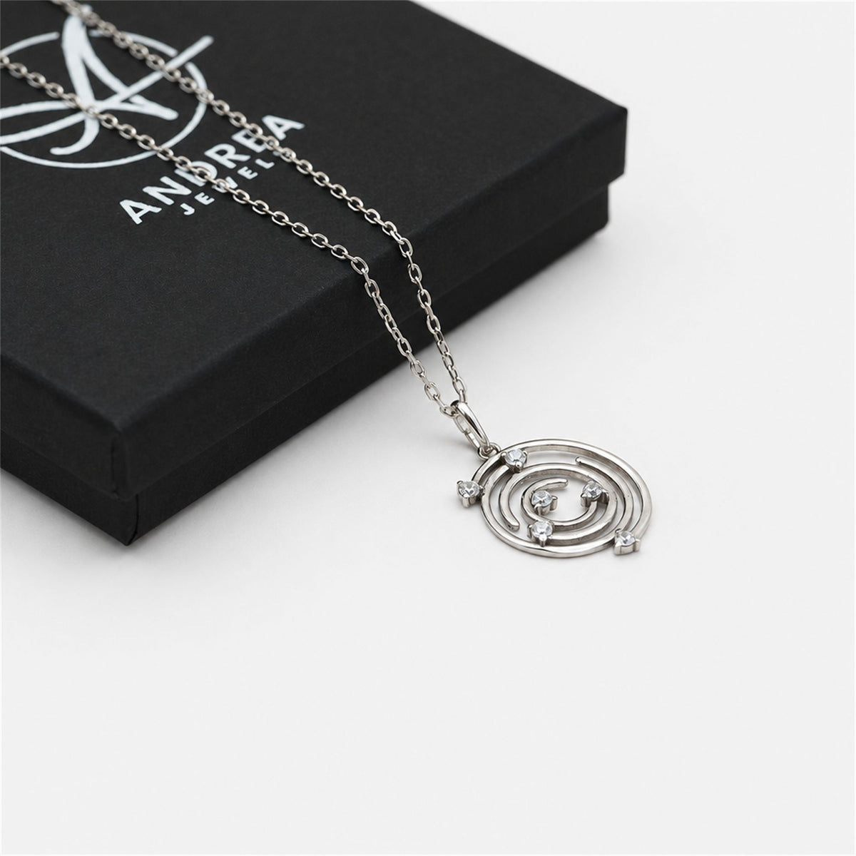 Collar Spiral de plata con piedra blanca junto a su caja de regalo cerrada - Andrea Jewels