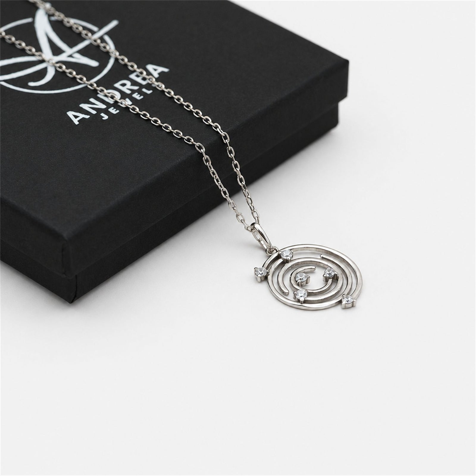 Collar Spiral de plata con piedra blanca junto a su caja de regalo cerrada - Andrea Jewels