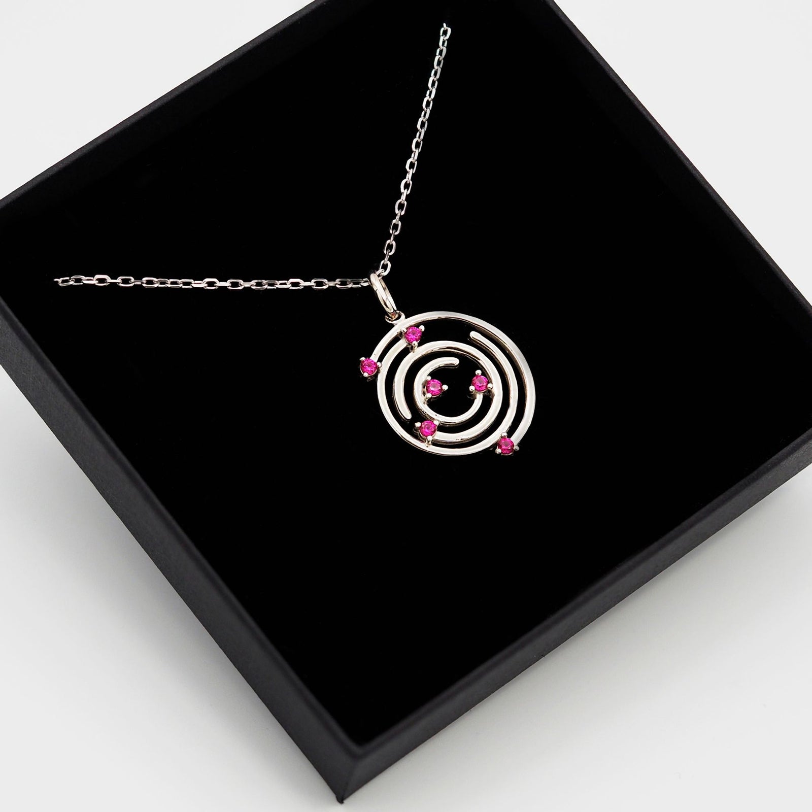 Collar Spiral de plata con piedra roja dentro de su caja de regalo abierta - Andrea Jewels
