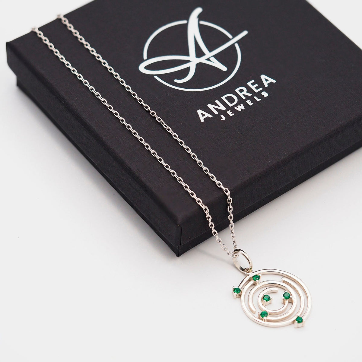 Collar Spiral de plata con piedra verde junto a su caja de regalo cerrada - Andrea Jewels