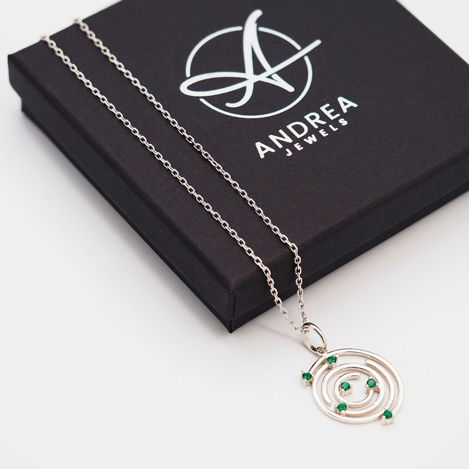 Collar Spiral de plata con piedra verde junto a su caja de regalo cerrada - Andrea Jewels