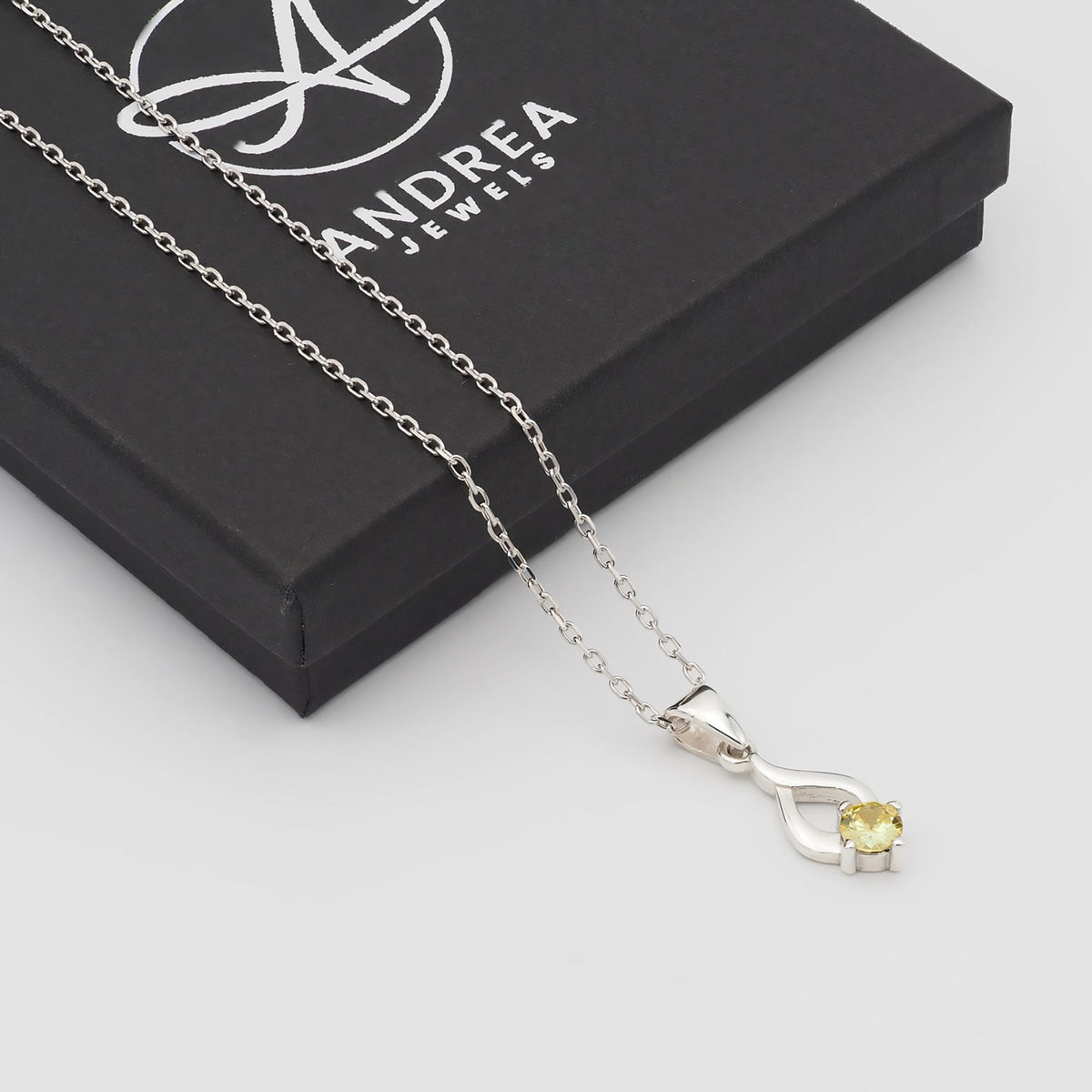 Collar Tear de plata con piedra amarilla junto a su caja de regalo cerrada - Andrea Jewels