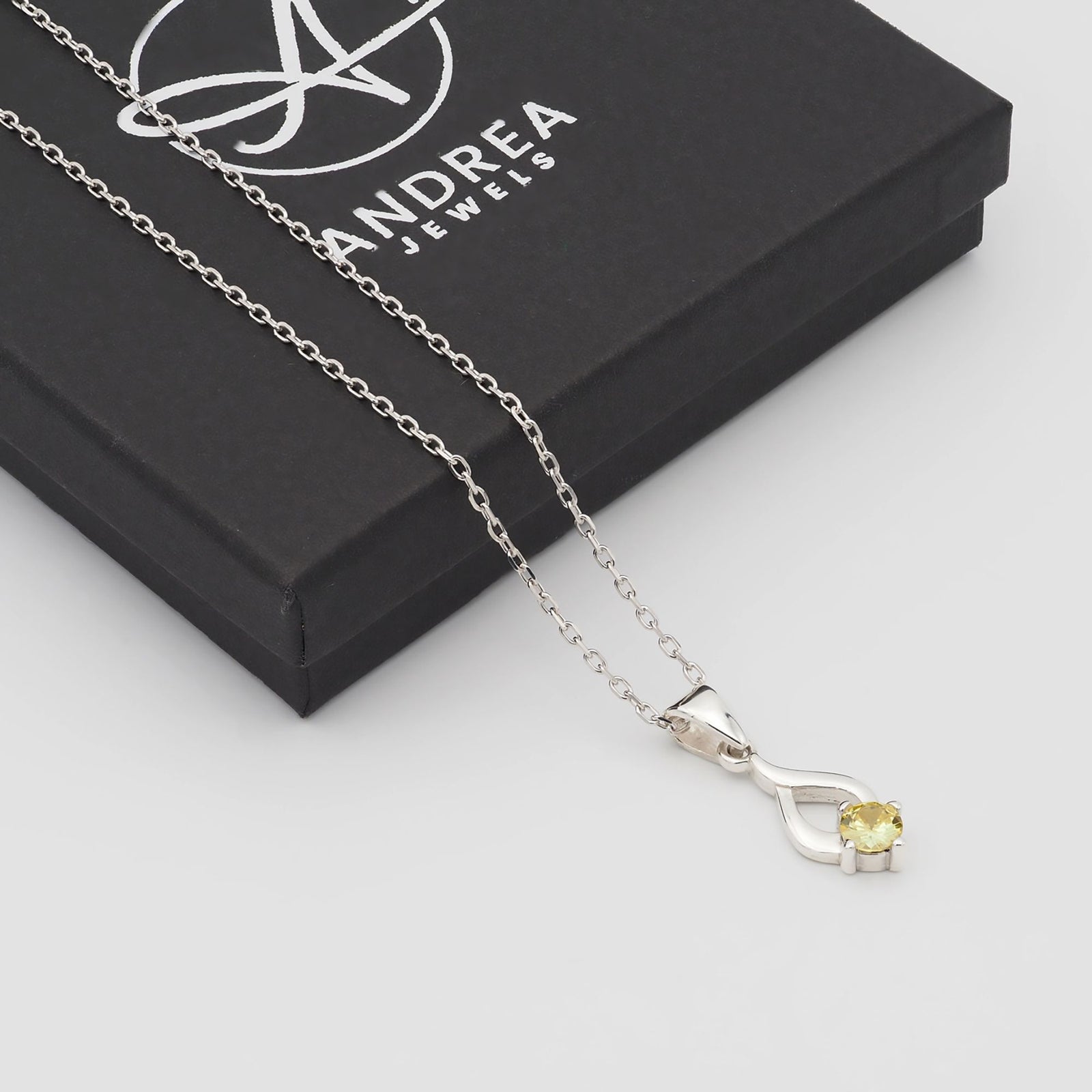 Collar Tear de plata con piedra amarilla junto a su caja de regalo cerrada - Andrea Jewels