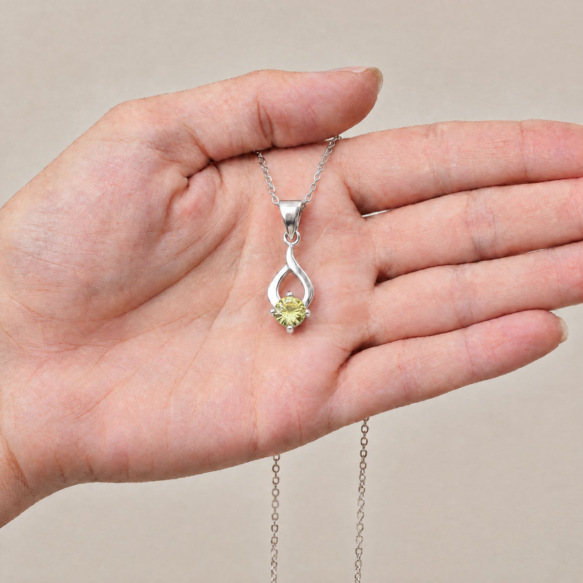 Collar Tear de plata con piedra amarilla sobre una mano - Andrea Jewels