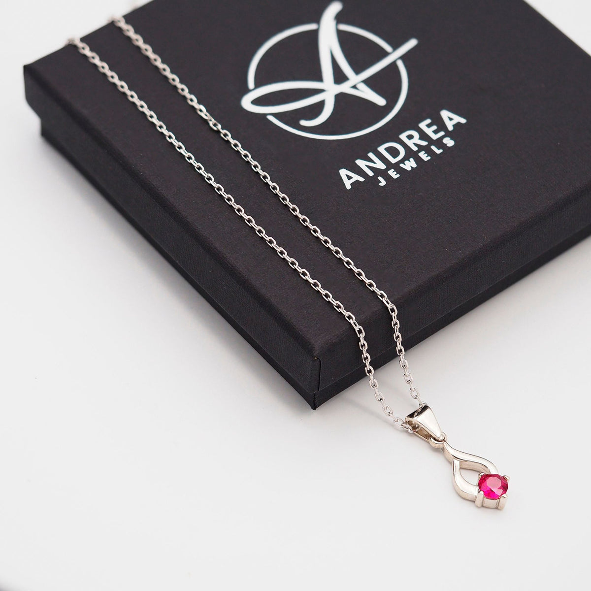 Collar Tear de plata con piedra roja junto a su caja de regalo cerrada - Andrea Jewels
