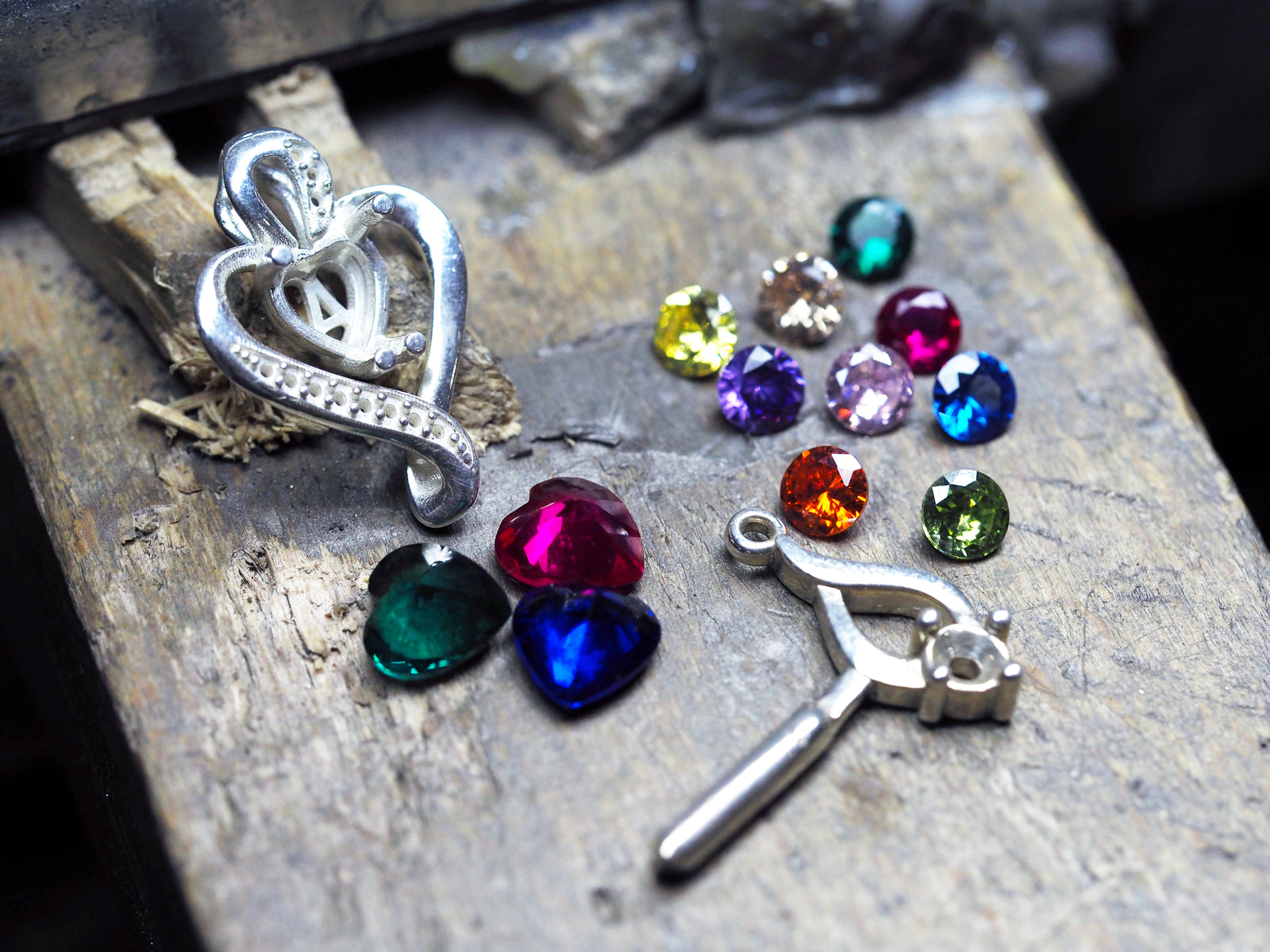 Colgante de corazón de plata y piedras de colores sobre el banco de trabajo - Andrea Jewels